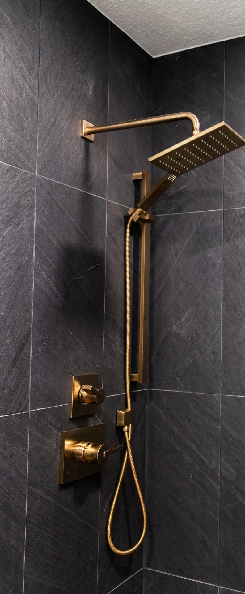 Whole-home remodel — brass shower fittings on slate tile, Orange, Avorino