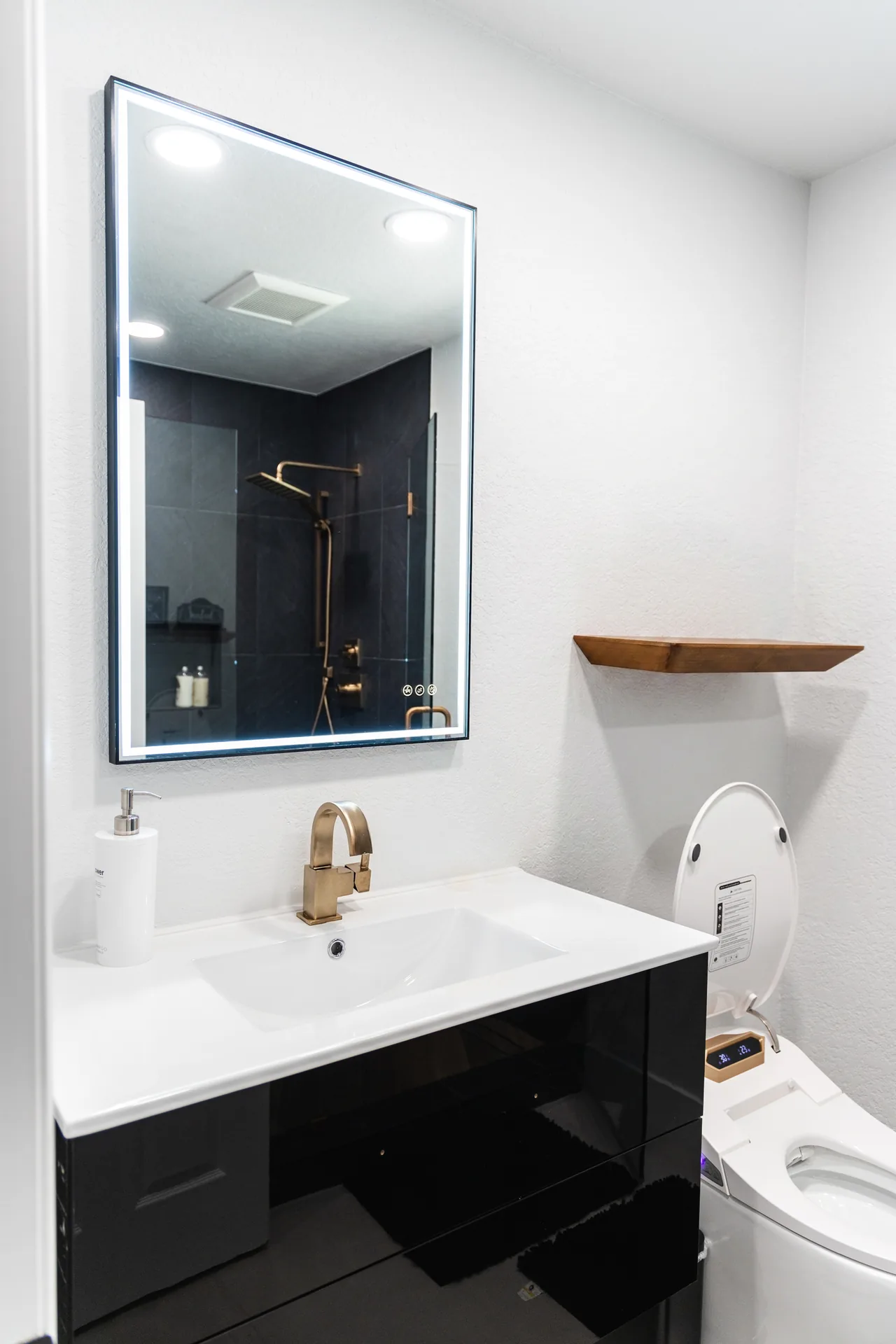 Whole-home remodel — bath vanity with lit mirror and floating shelf, Orange, Avorino