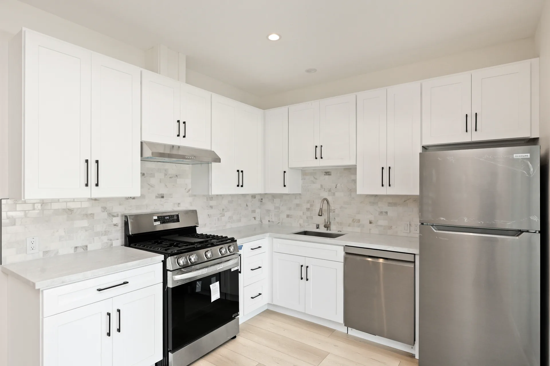 Garage conversion ADU — kitchen with white shaker cabinets and stainless appliances, Brea, Avorino