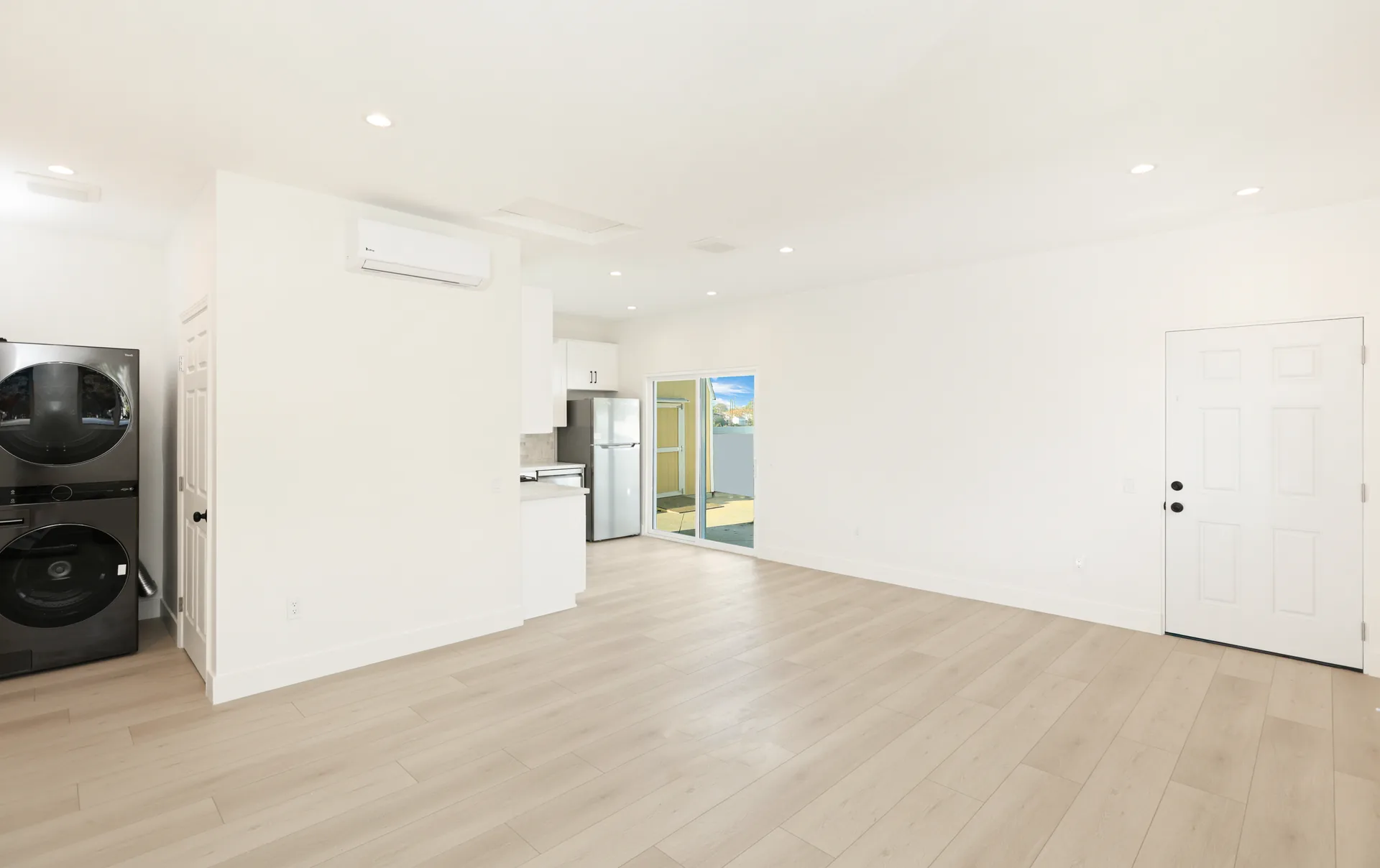 Garage conversion ADU — open living toward the kitchen and stacked laundry, Brea, Avorino