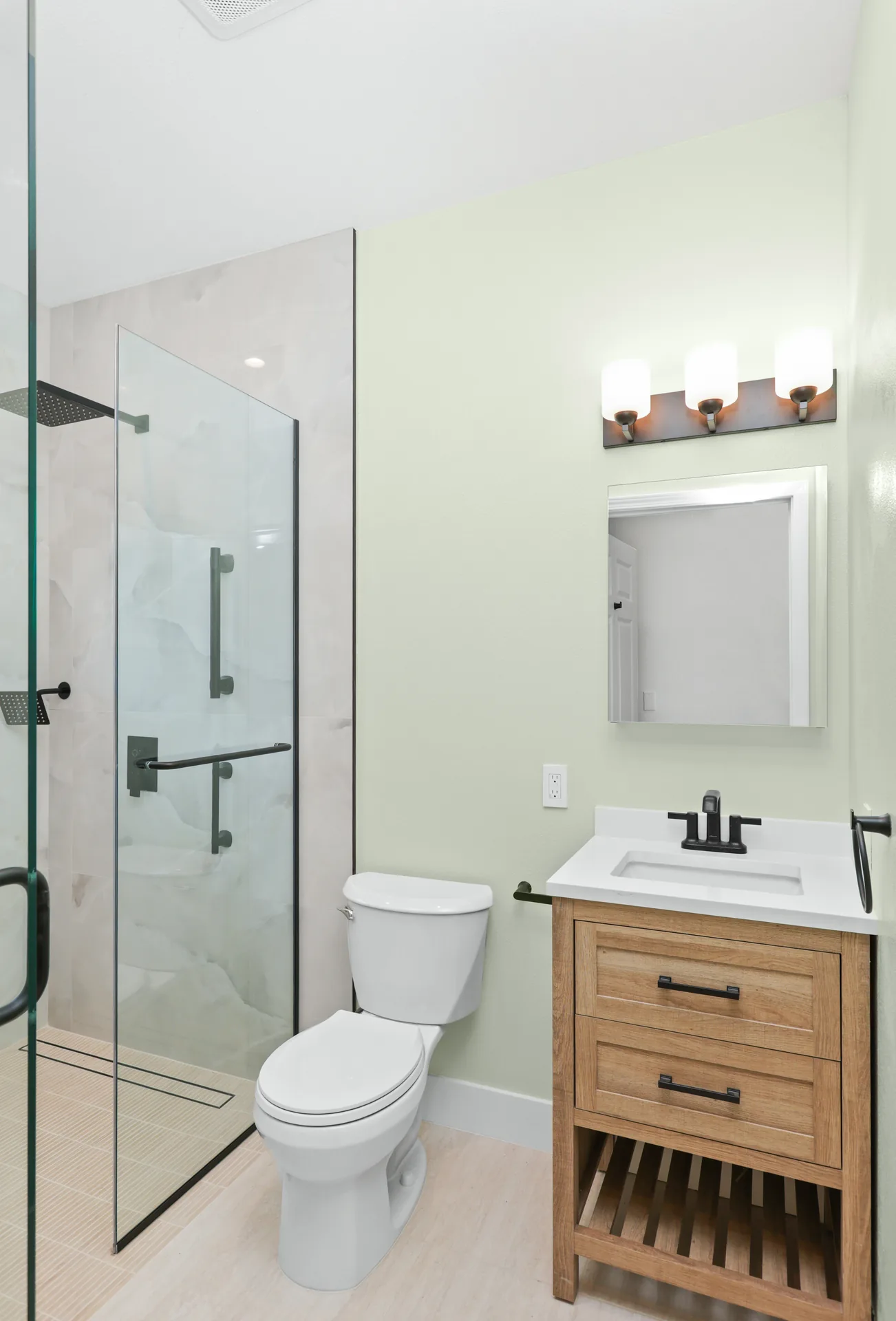 Garage conversion ADU — bath with glass shower and oak vanity, Brea, Avorino