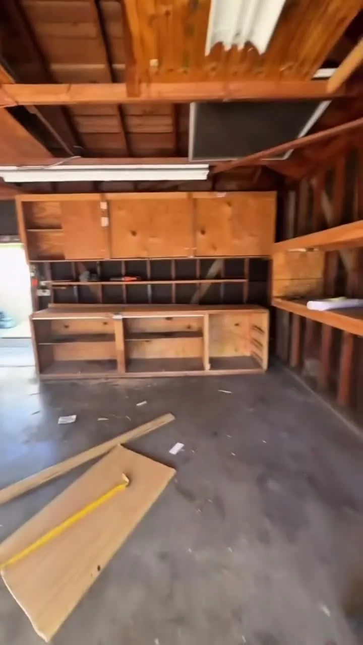 Garage conversion ADU — the original garage before conversion, exposed rafters and old shelving, Brea, Avorino