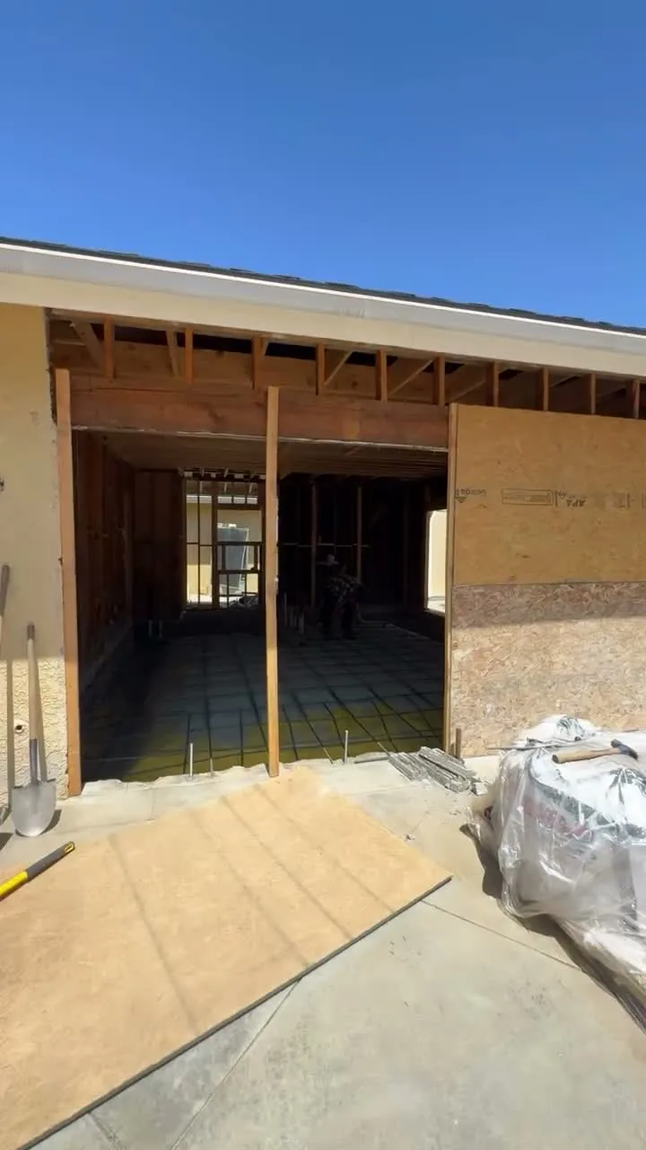 Garage conversion ADU under construction — garage opening stripped to studs with new sheathing, Brea, Avorino