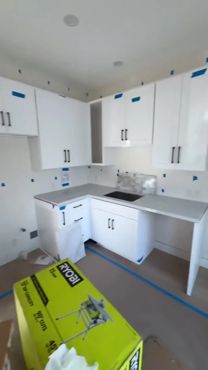 Garage conversion ADU under construction — white shaker cabinets installed, protection tape still on, Brea, Avorino