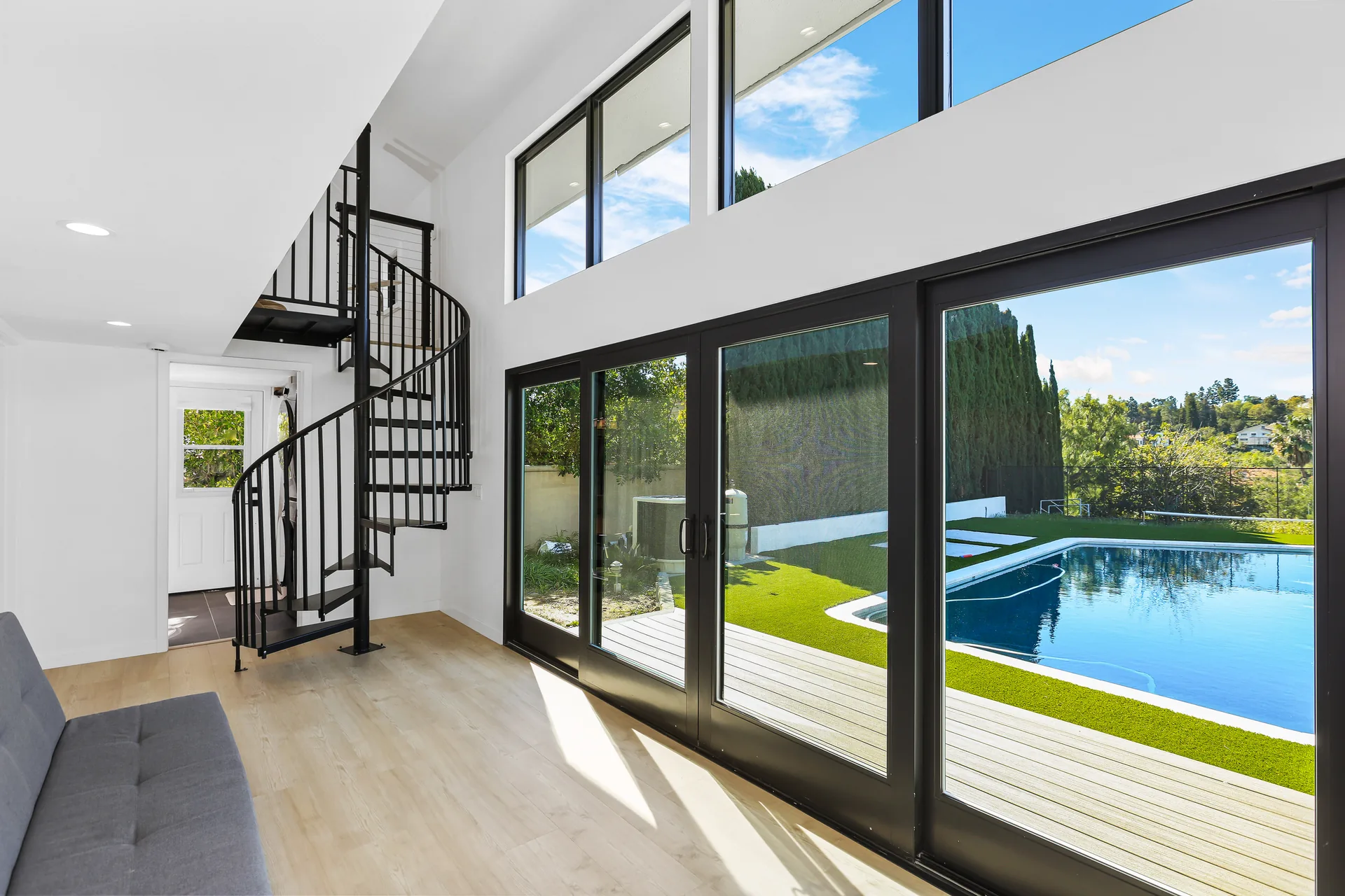 Two-story detached ADU — living room, spiral stair and sliders open to the pool, Santa Ana Hills, Avorino