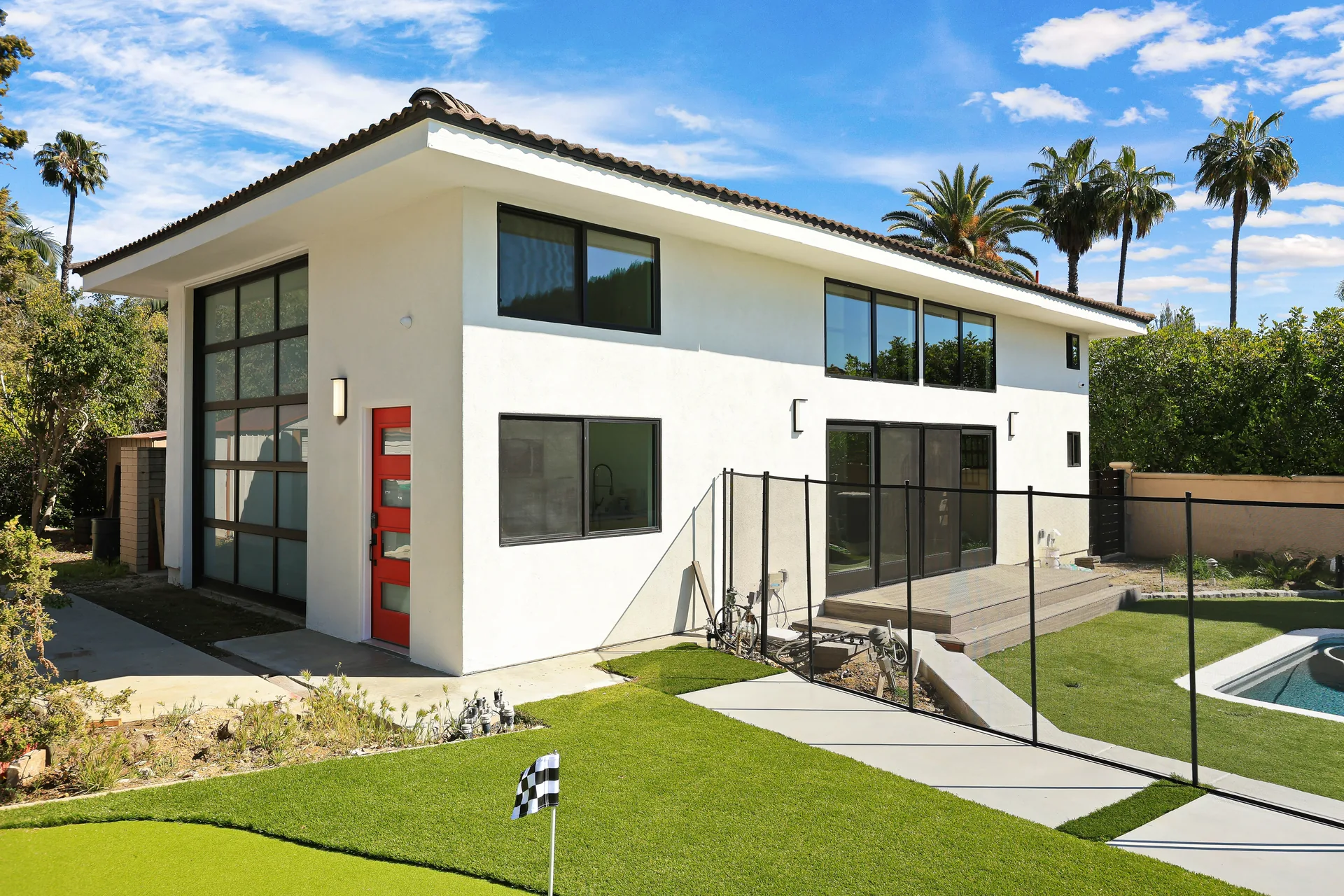 Two-story detached ADU, Santa Ana Hills — full exterior with the red entry door and pool, Avorino