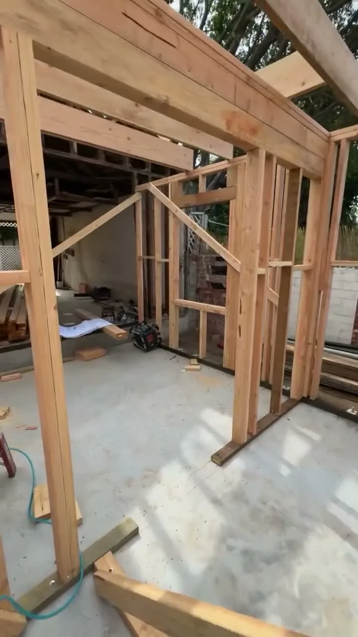 Attached ADU under construction — first wall framing and header beam on the new slab, Orange, Avorino