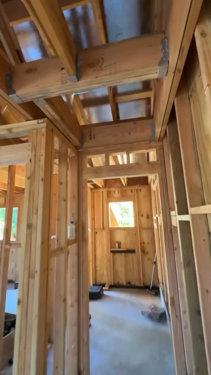 Attached ADU under construction — framed hallway with double headers and ceiling joists, Orange, Avorino